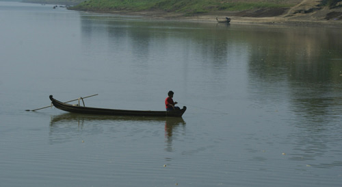 A fisherman and his paddle boat on the Ayeyarwaddy river - Bagan