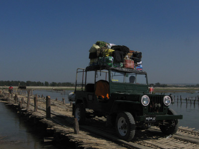 Jeep going over a temporary bridge in the flooded land